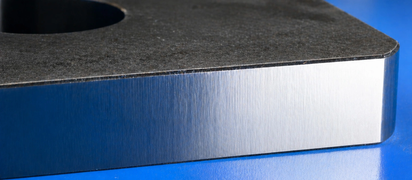 Mirror-like vertical cut edge on a 20mm carbon steel plate from high-power laser cutting.